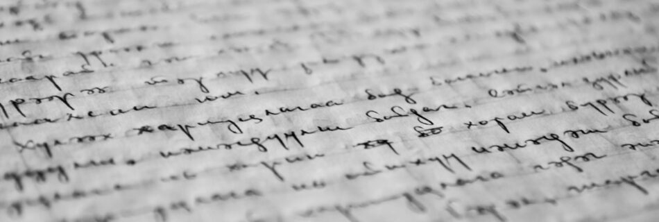 Close-up of vintage handwritten text on old paper, showcasing detailed penmanship and texture.