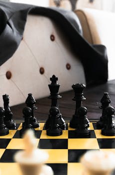 Close-up of chess pieces on a yellow board, highlighting strategy and focus.